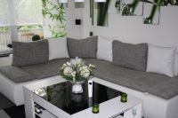 Weiße Kunstlederkissen kombiniert mit grauen Stoffkissen